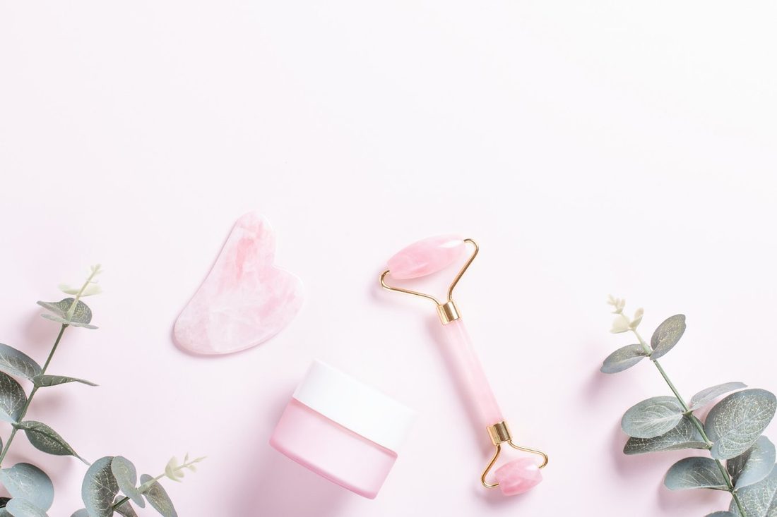 Rolo e pedra de Gua Sha de quartzo rosa com creme e eucalipto